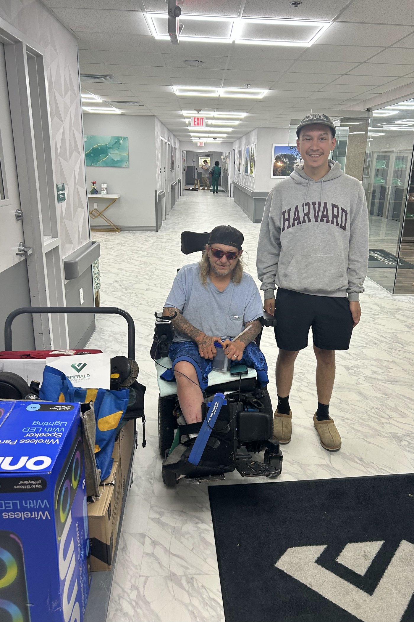 The owner's son alongside a client in a power wheelchair