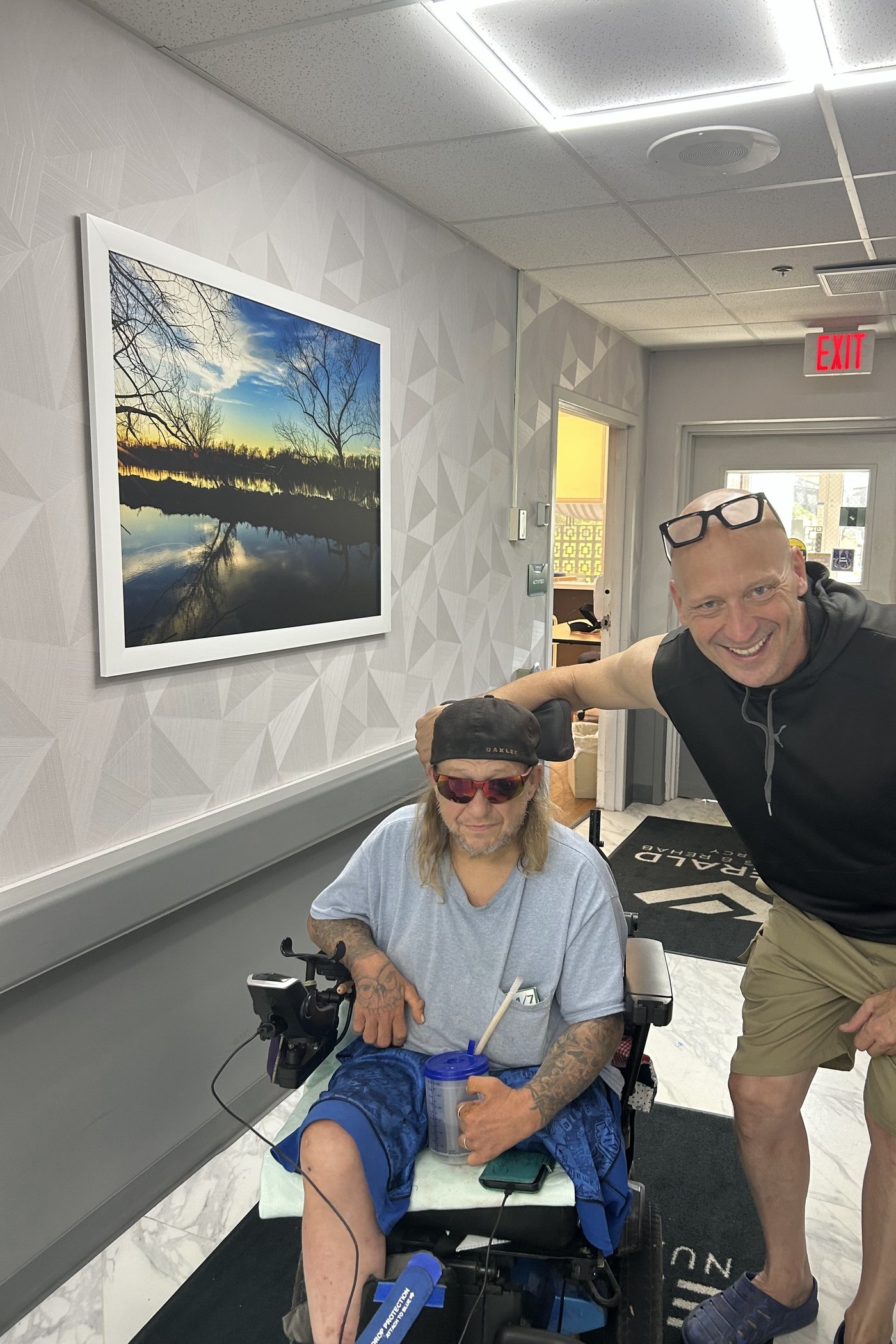 The owner with a client in a power wheelchair, both smiling