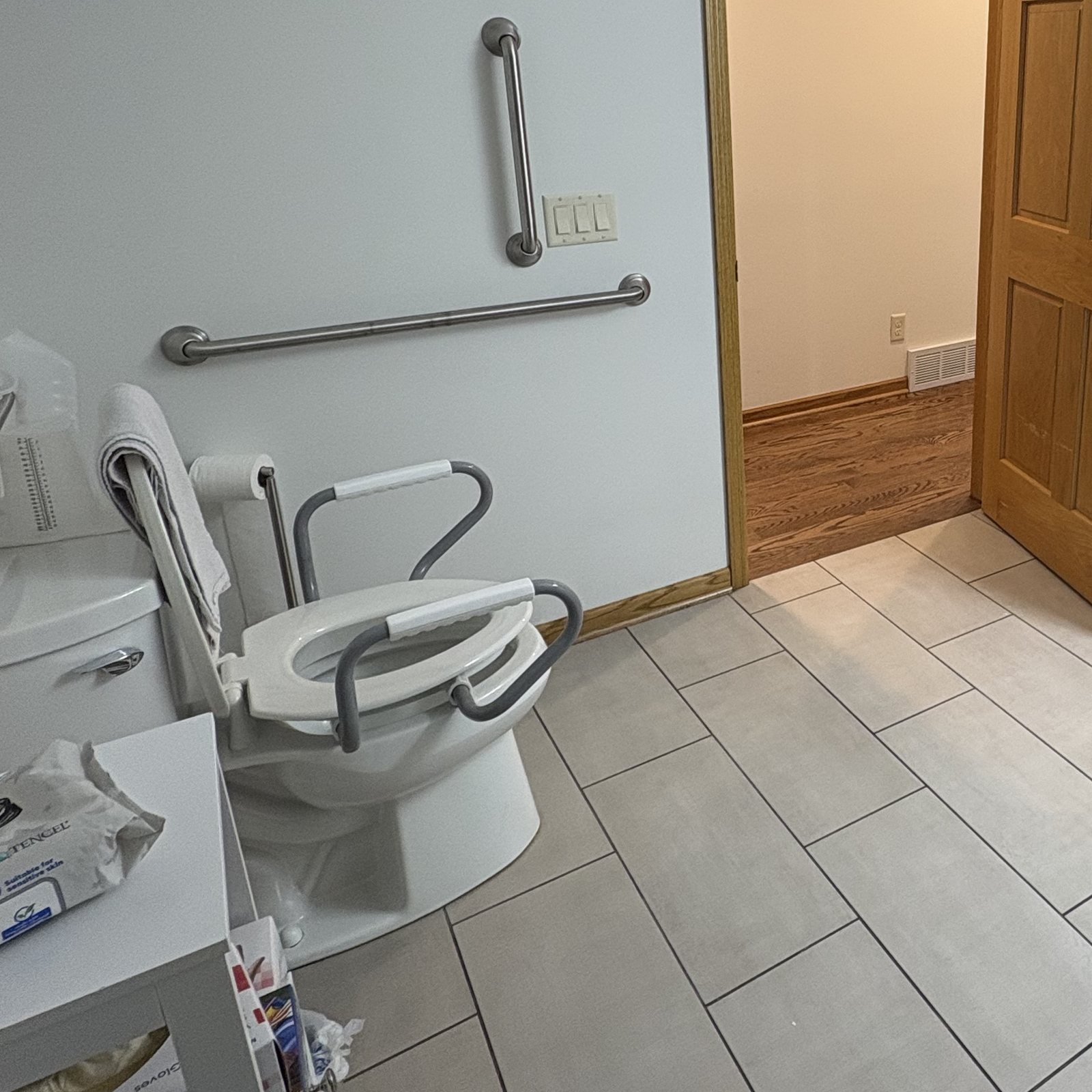 A bathroom fitted with grab bars and a roll-under sink